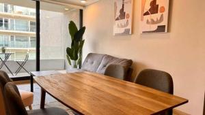 uma sala de estar com uma mesa e cadeiras de madeira em Exclusive Fully Equipped Apartment in Las Condes em Santiago