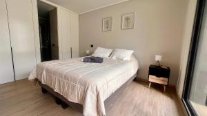 um quarto com uma cama grande com lençóis brancos em Exclusive Fully Equipped Apartment in Las Condes em Santiago