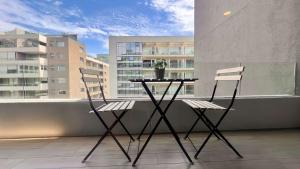 uma mesa e duas cadeiras sentadas numa varanda em Exclusive Fully Equipped Apartment in Las Condes em Santiago