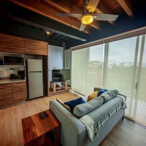 Una sala de estar con un sofá y una ventana grande. en Brick Box Loft con Balcon, en Hércules
