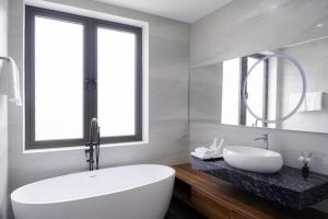 ダナンにあるVượng Phát Villa- Venuestayの大きな白い浴槽と洗面台のあるバスルーム +31枚の写真