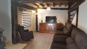 - un salon avec un canapé et une télévision dans l'établissement Camino de la Torre, à Quintana de Soba
