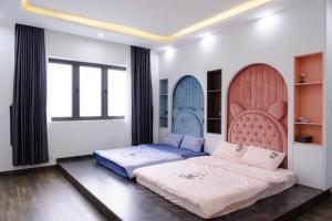 ダナンにあるVượng Phát Villa- Venuestayのベッドルーム1室(ベッド2台、大型ヘッドボード付)