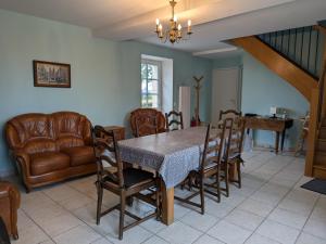 una sala da pranzo con tavolo, sedie e divano di Maison rénovée près d'Orléans avec animaux admis - FR-1-590-583 a Vennecy