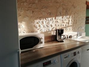 un forno a microonde seduto su un bancone in cucina di Maison rénovée près d'Orléans avec animaux admis - FR-1-590-583 a Vennecy