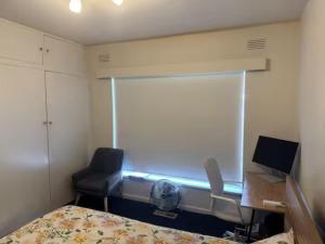 a bedroom with a bed and a desk and a chair at Spacious Room in Ivanhoe, Melbourne in Melbourne