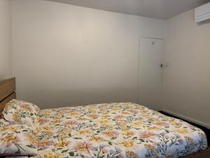 a bedroom with a bed with a floral comforter at Spacious Room in Ivanhoe, Melbourne in Melbourne