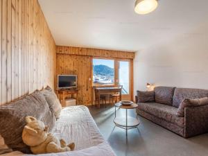 - un salon avec un ours en peluche assis sur un canapé dans l'établissement Studio idéal au Chinaillon pour 2 personnes - FR-1-458-258, au Chinaillon 5 autres photos