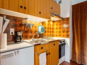 une cuisine avec des armoires en bois et un évier dans l'établissement Studio idéal au Chinaillon pour 2 personnes - FR-1-458-258, au Chinaillon