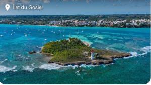 a lighthouse on a small island in the ocean at La BEL KREOL in Le Gosier