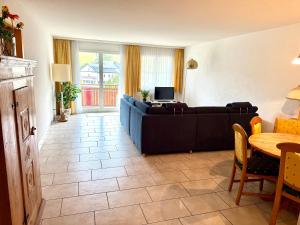 a living room with a couch and a table at Haus Alpina - CharmingStay in Flumserberg