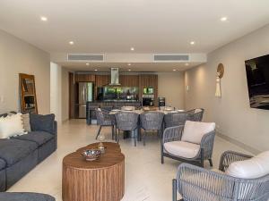 a living room with a couch and a table and chairs at Luxury Retreat in Puerto Cancun with Rooftop Pool in Cancún