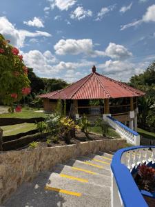 a gazebo with a building in a park at Finca hotel villa Román in Montenegro