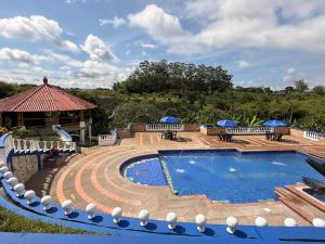 a swimming pool with benches and a gazebo at Finca hotel villa Román in Montenegro