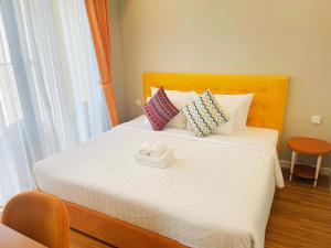 a bedroom with a bed with white sheets and pillows at We Young Apartments by HOFs - Fireworks & Ocean view in Phú Quốc
