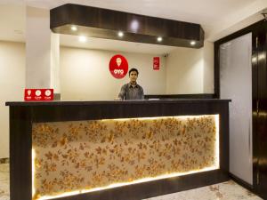 a man standing behind a counter in a lobby at Collection O Park Heights Banjara Hills Near Gvk One Mall in Hyderabad +36 photos