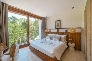 Un dormitorio con una cama grande y una ventana grande. en Villa Jaran - NEW 2BR Uluwatu Escape with Rooftop, Near Beaches!, en Uluwatu