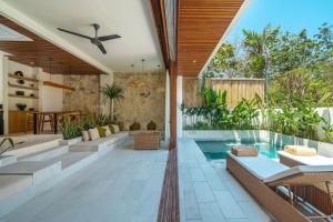 una sala de estar abierta con piscina y una casa en Villa Jaran - NEW 2BR Uluwatu Escape with Rooftop, Near Beaches!, en Uluwatu