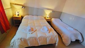 a hotel room with two beds and two lamps at Departamento ITATI in General Alvear