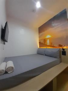 a room with a bed with a painting on the wall at Happy Island Inn in Virac