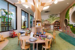 a classroom with a table and chairs and a tree mural at Anantara Bophut Koh Samui Resort in Bophut