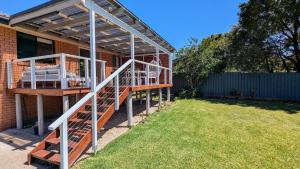 ein Haus mit einer Pergola an der Seite in der Unterkunft Charming Coastal Cottage Retreat in Vincentia