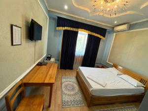 a bedroom with a bed and a table and a chandelier at Ak zhol in Almaty