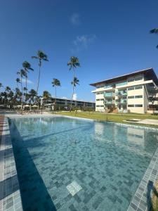 a swimming pool in front of a building at Apartamento Ipioca Beach Life - Maceió in Maceió +27 photos