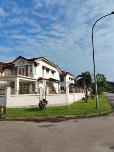 a white house on the side of a street at Mummy Homestay Pulai in Johor Bahru