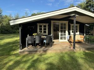 a house with a deck with a table and chairs at Summerhouse Near Marielyst Beach With Large Garden in Marielyst