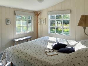 a bedroom with a bed with two pillows and two windows at Summerhouse Near Marielyst Beach With Large Garden in Marielyst