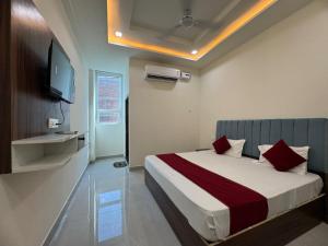 - une chambre avec un lit et une télévision murale dans l'établissement Grand Place Near by Prem Mandir, à Jāmb 13 autres photos