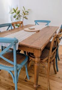 ein Holztisch mit Stühlen und ein Holztisch mit in der Unterkunft Charming Coastal Cottage Retreat in Vincentia