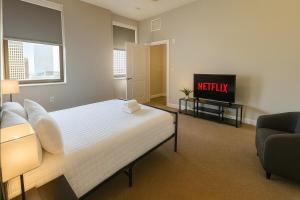 Un dormitorio con una cama y un televisor. en Downtown Luxe Suite Rock Hall, Casino, Stadiums, en Cleveland 17 fotos más