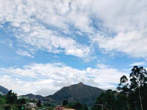 a cloudy sky with a mountain in the background at Nakshatra Homestay in Vattavada