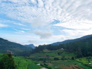 a view of a green valley with mountains and clouds at Nakshatra Homestay in Vattavada