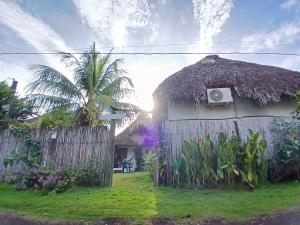 a house with a thatch roof and a fence at The Birds HOTEL El Paredón in El Paredón Buena Vista