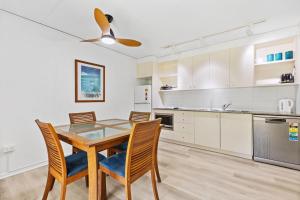 a kitchen with a dining room table and chairs at Baden 59 - Rainbow Shores - Pool - Tennis Court - Walk to beach in Rainbow Beach