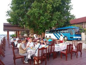 a group of people sitting at tables at a restaurant at Senesothxuene Hotel in Muang Không
