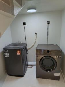 a laundry room with a washing machine and a light at ZZD Gunong Roomstay in Bachok
