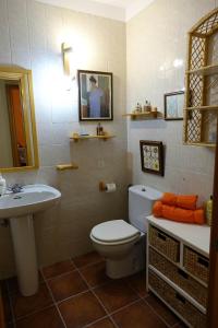 a bathroom with a white toilet and a sink at Casa Rural del Sol in Zamarramala