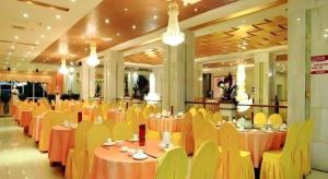 a banquet hall with tables and yellow chairs at Exchange Bank Hotel Hainan in Haikou