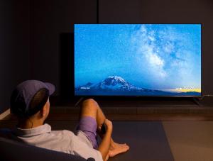 a man sitting in a chair watching a television at yah homes takasago in Fukuoka