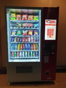 a refrigerator filled with lots of drinks and soda at V51 Hotel in Nakhon Ratchasima