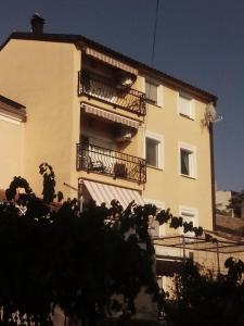 a building with balconies and a tree in front of it at Apartment Ksenija in Crikvenica