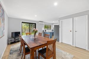 a kitchen and dining room with a wooden table and chairs at The Pawfect Beach House in Cowes +8 photos