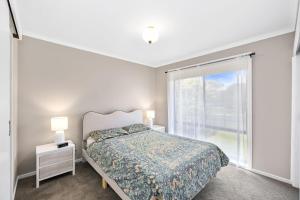 a bedroom with a bed and a large window at The Pawfect Beach House in Cowes