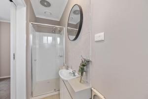 a white bathroom with a sink and a shower at The Pawfect Beach House in Cowes