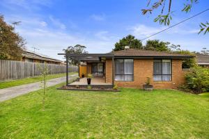 a brick house with a lawn in front of it at The Pawfect Beach House in Cowes