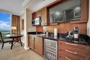 a kitchen with wooden cabinets and a table with a counter top at Sakura Serenity-View-No Resort Fee in Las Vegas
